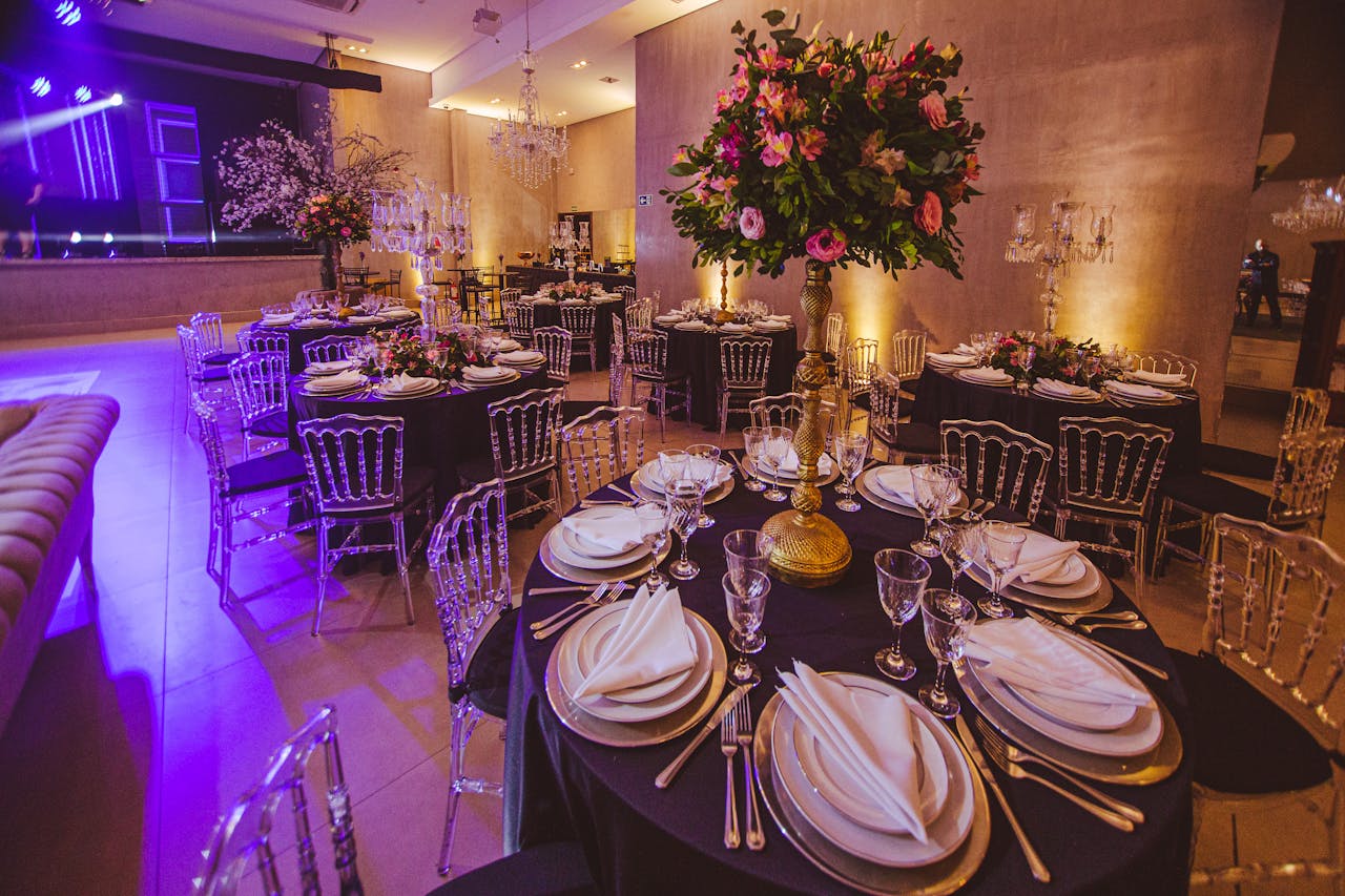 Lavish dining room setup featuring floral arrangements, elegant table settings, and ambient lighting for a private function.