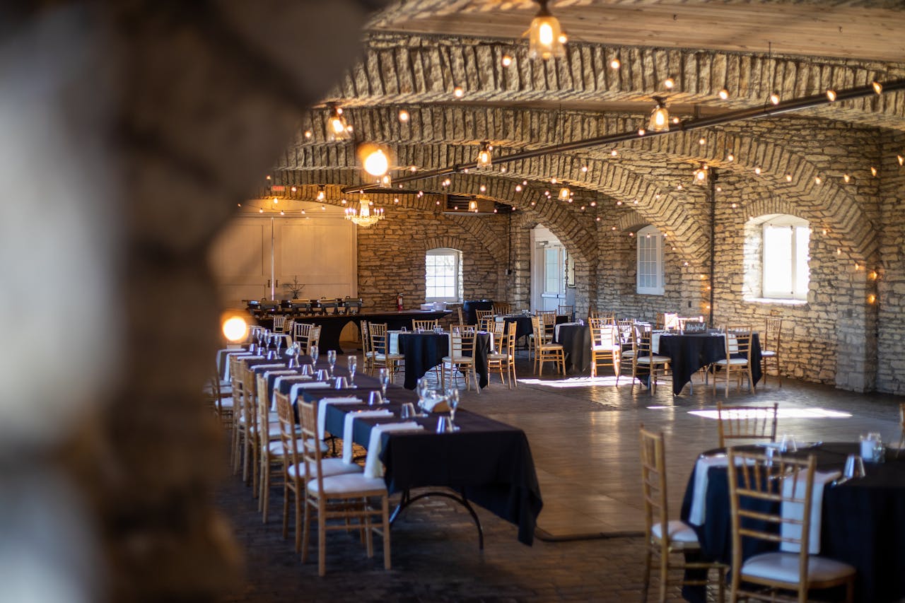 Beautiful rustic venue with wooden chairs, stone walls and natural lighting.